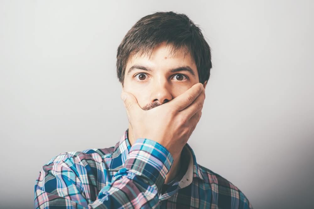Man holding his face embarrassed about gum disease