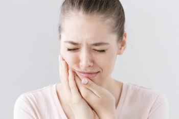 Woman holding her face due to a toothache