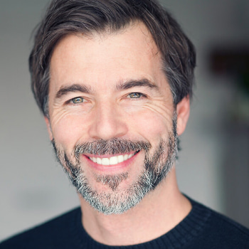 A mature man with beard smiling