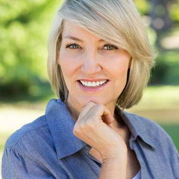 Blonde Woman with short hair smiling outdoors 