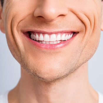 Close up of a man smiling on a light background