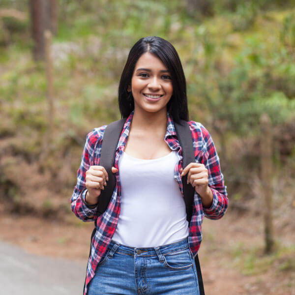 An image of a young woman with a backpack outdoors